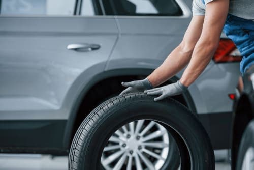 Mechanic rolling a new tire for installation